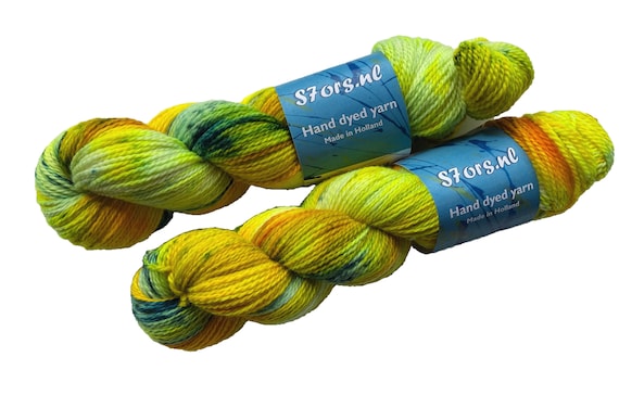 Hand dyed superwash Merino 4 ply sock weight yarn. Fluorescent warm yellow with blue speckles.