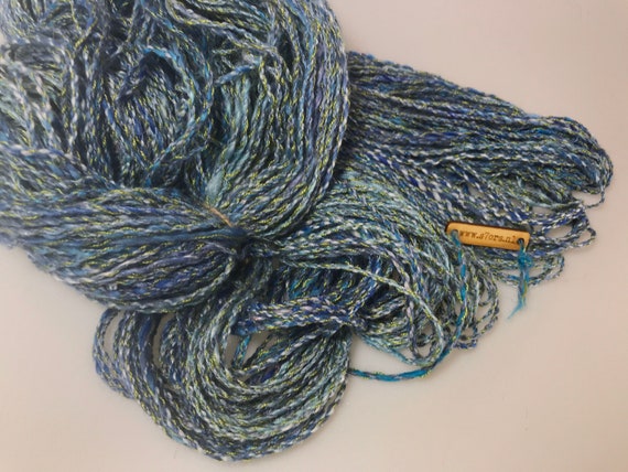 Hand spun six ply art yarn in blue, green and white with a little glitter. 150 grams by 229 meters or 5.2 ounce by 751 feet.