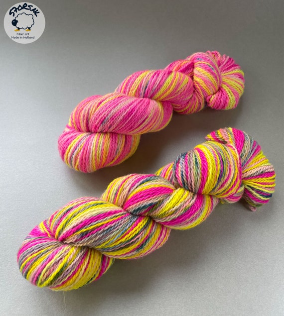 Hand dyed, self striping Polwarth and Tussah silk sock yarn. Fluorescent pink, yellow and speckles.