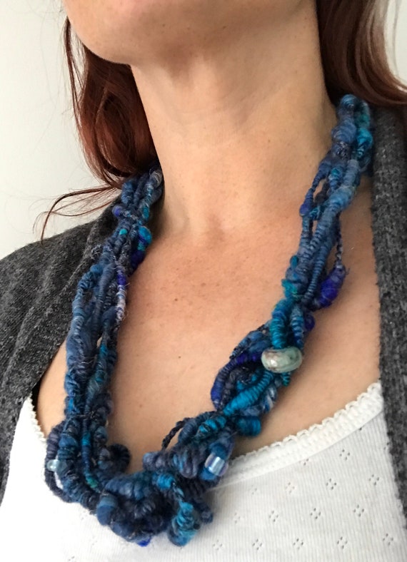 Beaded art yarn necklace. Handspun out of merino wool, silk, tencel, mohair and angelina glitter. In all shades of dark blue.