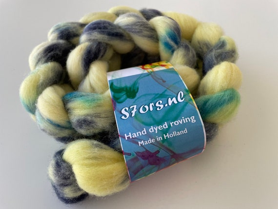 Hand dyed German Merino top 25 micron. Ideal for spinning or felting. Soft yellow with blue speckles.