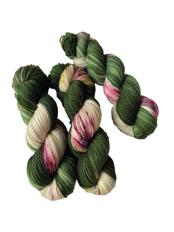 Hand dyed superwash Merino 4 ply sock weight yarn. Pooling green and pink speckled