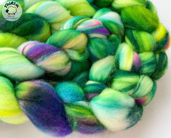 Hand dyed superwash extra fine Merino top. ‘Iris’. Specled dyed roving with fluoriscent accents.