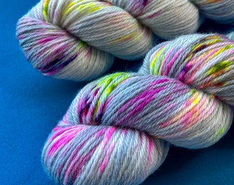 Handgeverfd superwash Merino, kasjmier en nylon DK-gewichtsgaren. Half effen staalgrijs met fluorescerende spikkels.