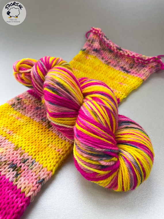 Self striping hand dyed superwash Merino DK weight yarn. Fluoriscent pink with yellow and speckled light pink.