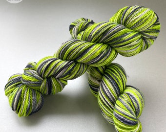 Handgeverfd, zelfstrepend, superwash merino en bio nylon sokkengaren. Fluorescerend groen, staalblauw en zilvergrijs.