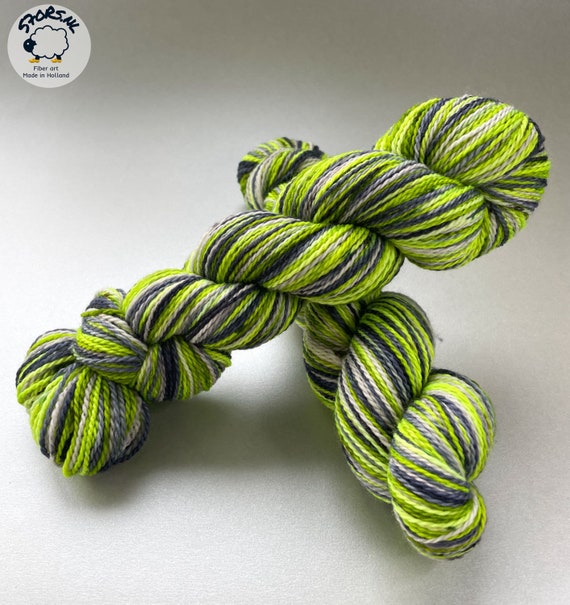 Hand dyed, self striping, superwash merino and bio nylon sock yarn. Fluorescent green, steel blue and silver grey.