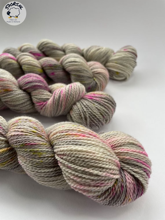 Hand dyed Superwash Merino, A Grade Mulberry Silk and Cashmere sock weight yarn. Platinum grey with pink an chartreuse speckles.