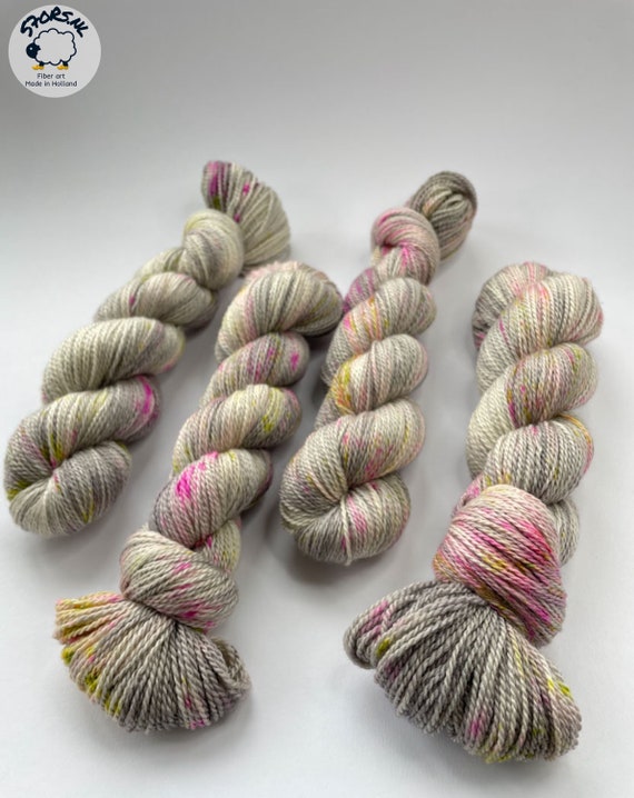 Hand dyed Superwash Merino, A Grade Mulberry Silk and Cashmere sock weight yarn. Platinum grey with pink an chartreuse speckles.