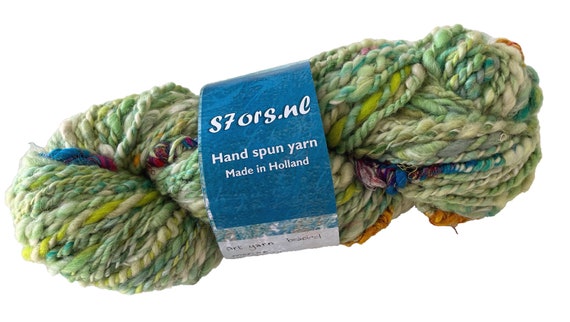 Hand spun beaded art yarn. Green merino/alpaca blend with sari silk supercoils.