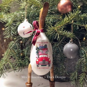 Driving home for Christmas. Wooden duck in boots, with vintage style car, and Christmas scene.