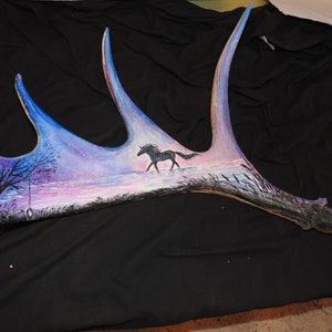 Unicorn silhouette painting, tree and tire swing on moose antlers