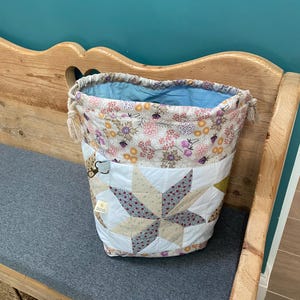 Bolsa grande para proyectos de tejido patchwork con cordón ajustable.