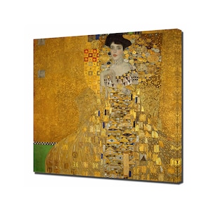 Op de afbeelding: Een schilderij van een vrouw in een gouden jurk met een geometrisch patroon. De achtergrond is ook goudkleurig met een geometrisch patroon.