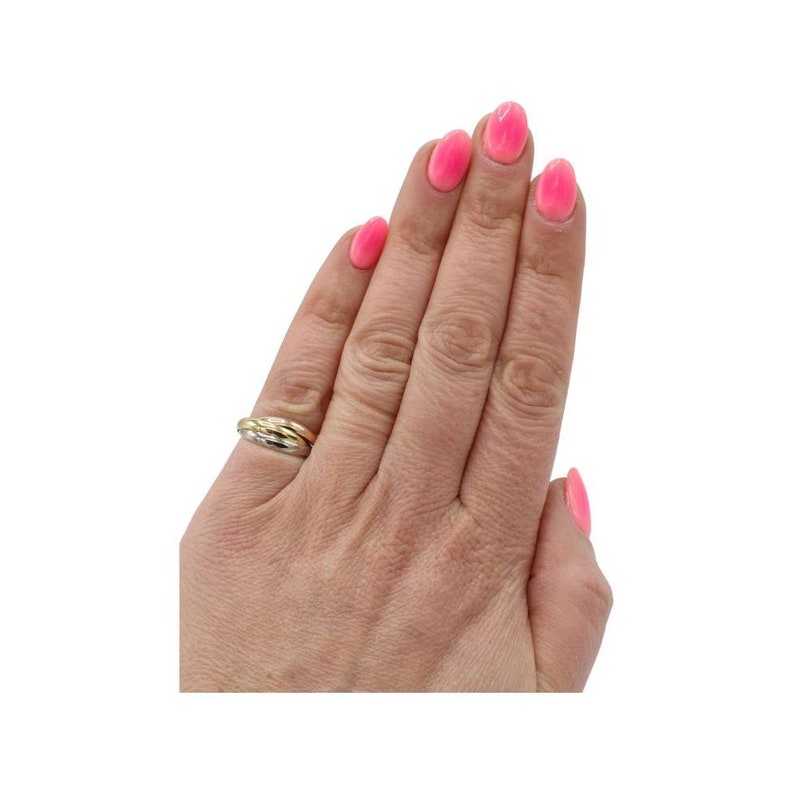 May include: A gold, silver, and white wedding band ring.
