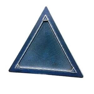 May include: A blue triangular ceramic tray with a decorative silver border. The tray has a smooth, slightly textured surface.