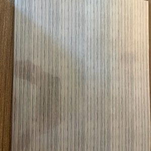 May include: A white sheet of paper with a gray and white striped pattern.