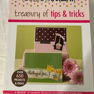 May include: A book titled "Paper Crafts & Stamp It! Magazine: Treasury of Tips & Tricks" with a pink, green, and brown polka dot pattern on the cover. The book features a close-up of a handmade card with a cupcake and the words "Happy Birthday". The book also features a handmade card with the words "Thinking of you". The book cover states "Over 650 Projects & Ideas".