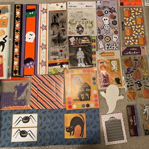 May include: A collection of Halloween themed scrapbook paper and stickers. The paper features various patterns, including stripes, polka dots, and bats. The stickers feature images of ghosts, pumpkins, bats, and other Halloween icons. The text on the stickers includes "Boo!" and "Trick or Treat".