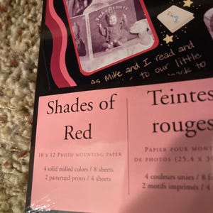 May include: Photo mounting paper titled "Shades of Red" with a woman reading a book. The package includes 10 x 12 inch paper with 4 solid milled colors and 2 patterned prints.