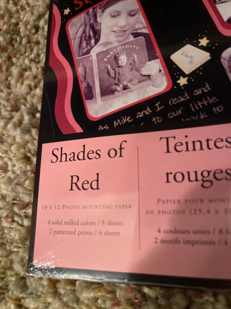 May include: Photo mounting paper titled "Shades of Red" with a woman reading a book. The package includes 10 x 12 inch paper with 4 solid milled colors and 2 patterned prints.