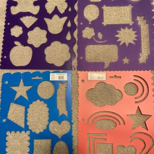 May include: Four plastic stencils with different shapes and designs. The stencils are purple, blue, and pink. The shapes include stars, hearts, clouds, rainbows, and more.