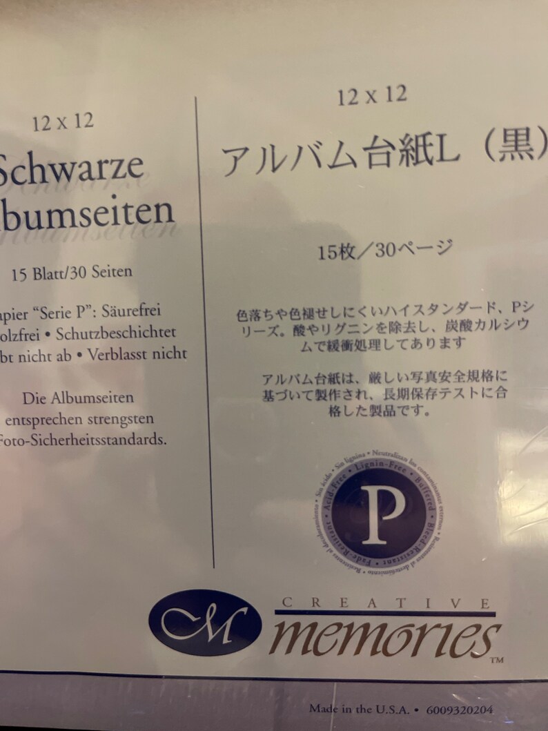 May include: A black photo album with the text "Schwarze bumseiten" and "Albumseiten entsprechen strengsten Foto-Sicherheitsstandards."  The album is 12 x 12 inches and holds 15 sheets or 30 pages.