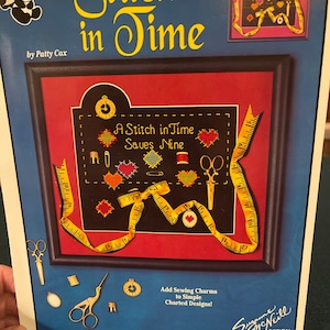 May include: A cross-stitch pattern booklet titled "Stitch in Time" by Patty Cox. The cover features a framed cross-stitch design of a sewing kit with the saying "A Stitch in Time Saves Nine".