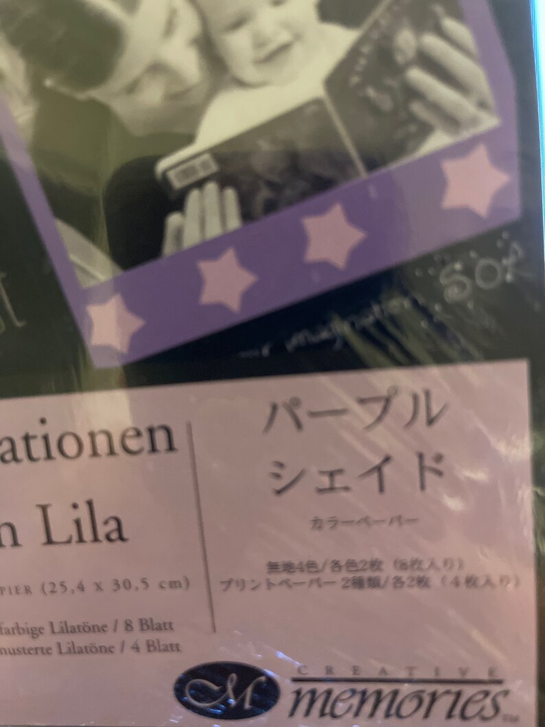 May include: Purple and white paper pack with a photo of a mother and child reading a book. The pack includes 8 sheets of patterned paper and 4 sheets of solid color paper. The paper is 25.4 cm by 30.5 cm.