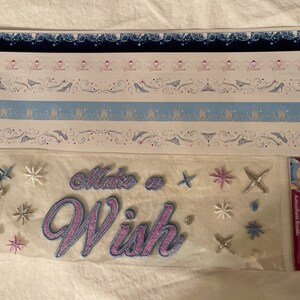 May include: A sheet of Disney princess themed stickers with a variety of designs, including castles, crowns, and stars. The stickers are embroidered and have a pink and blue color scheme. The sheet also includes the text "Make a Wish".