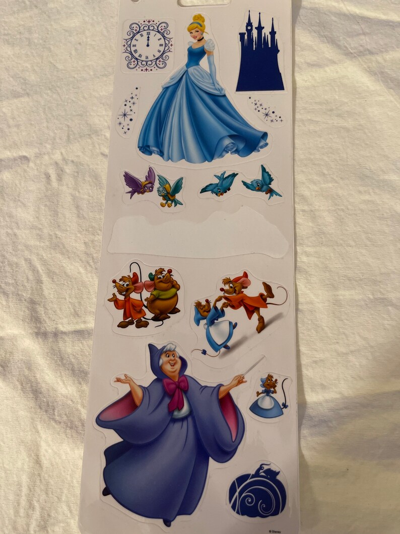 May include: A set of Cinderella-themed stickers featuring Cinderella in her blue ball gown, a clock, a castle, birds, mice, and the Fairy Godmother.
