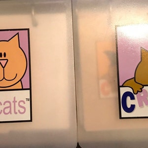 May include: Two cartoon cats with the text "COPYcats" in blue letters on a purple background. The cats are orange and brown and have black eyes and noses.