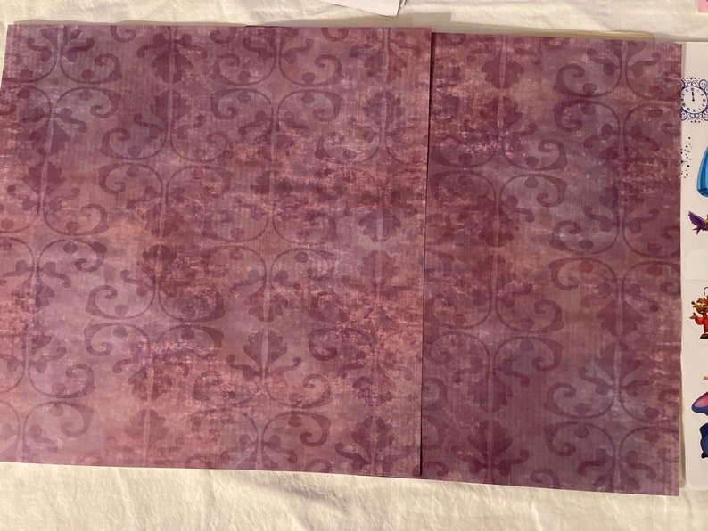 May include: Two sheets of purple patterned paper with a subtle distressed look. The pattern is a repeating floral design.