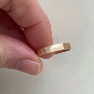 May include: A gold hammered band ring.