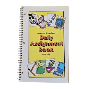 May include: A yellow and white spiral bound daily assignment book with the title "Daily Assignment Book" and the text "Hammond & Stephens" and "Form 1165". The cover features colorful illustrations of school supplies, including a music note, a globe, a calculator, a beaker, a protractor, and a computer.