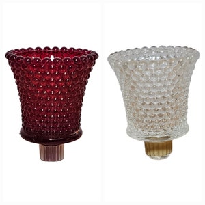 May include: Two glass candle holders, one red and one clear, with a textured bubble design.