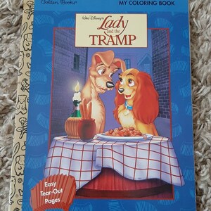 May include: A coloring book featuring Lady and the Tramp from Disney. The cover shows Lady and Tramp sharing a plate of spaghetti. The book has easy tear-out pages. The title of the book is "Lady and the Tramp" and it is a Golden Books publication.