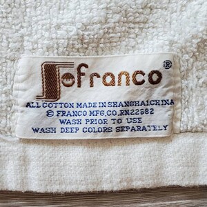May include: White towel with a brown "Jofranco" label. The label includes the text "All cotton made in Shanghai China", "Franco Mfg. Co. RN22682", "Wash prior to use", and "Wash deep colors separately."