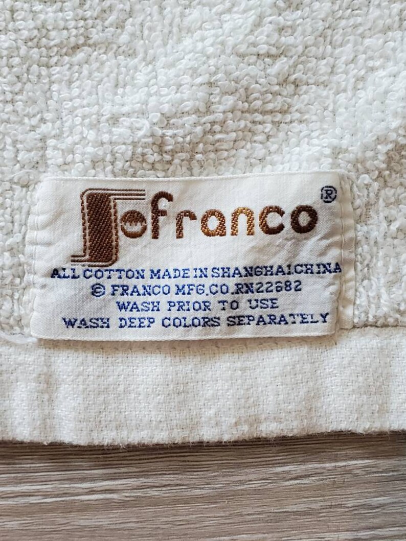 May include: White towel with a brown "Jofranco" label. The label includes the text "All cotton made in Shanghai China", "Franco Mfg. Co. RN22682", "Wash prior to use", and "Wash deep colors separately."