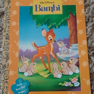 May include: A coloring book featuring Bambi from Disney's Bambi. The cover shows Bambi, a young deer, with Thumper and other rabbits. The book has easy tear-out pages and is designed for children. The book cover is orange with a white border and features the text "My Coloring Book with Activities" and "Walt Disney's Bambi".