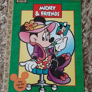May include: A coloring book featuring Mickey Mouse and friends. The cover shows Minnie Mouse wearing a pink hat and a floral dress, holding a pencil and looking at a picture of Mickey Mouse. The book is titled "My Coloring Book: Mickey & Friends" and is labeled "All Ages".