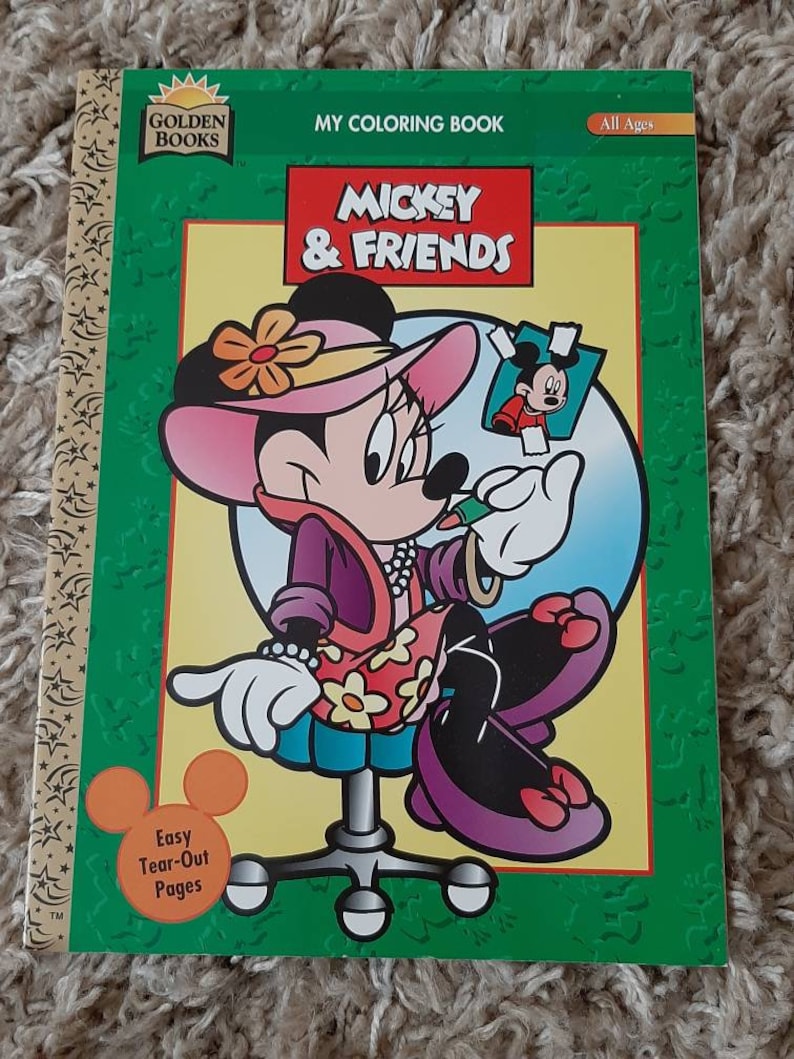 May include: A coloring book featuring Mickey Mouse and friends. The cover shows Minnie Mouse wearing a pink hat and a floral dress, holding a pencil and looking at a picture of Mickey Mouse. The book is titled "My Coloring Book: Mickey & Friends" and is labeled "All Ages".