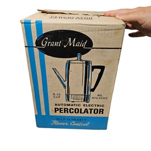 May include: A vintage Grant Maid automatic electric percolator coffee maker in a blue and white box. The box features the text "Grant Maid", "Automatic Electric Percolator", "Mild to Hearty Flavor Control", "5-10 Cup", and "No. WTG-90621".