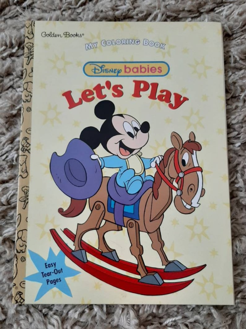 May include: A coloring book featuring Disney babies. The cover shows Mickey Mouse riding a rocking horse. The title of the book is "Let's Play".