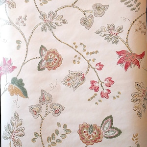 May include: A vintage wallpaper with a floral pattern. The wallpaper features a repeating design of pink and green flowers with brown stems and leaves.