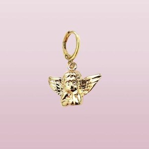 May include: Gold-toned angel charm with wings and a hoop earring attachment.
