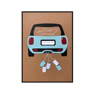 Carte de mariage « Just Married » avec des boîtes de conserve attachées sur la voiture