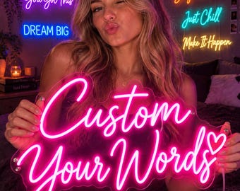 May include: A bright pink neon sign featuring the text Custom Your Words with a small heart symbol at the end. The sign is mounted on a clear acrylic backing and emits a vibrant glow, displaying the words in a flowing, cursive script font.