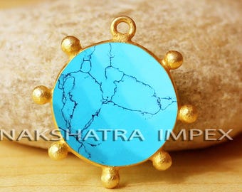 May include: A round pendant with a bright turquoise stone center and gold-colored accents. The pendant has a loop at the top for hanging and is surrounded by six gold-colored spheres. The pendant is set against a neutral background.