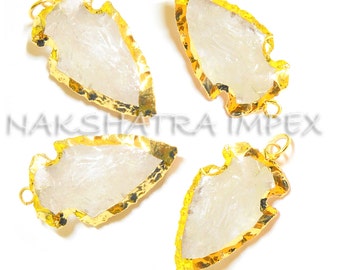 May include: Four white arrowhead shaped pendants with gold-toned metal trim. The pendants have a rough, natural texture.